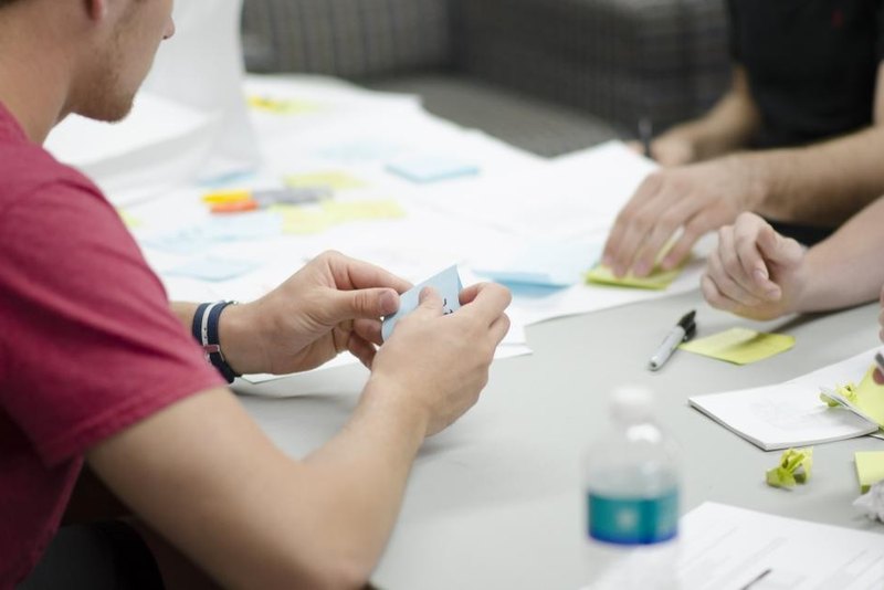 Equipo diseñando un proyecto académico con notas y esquemas sobre la mesa
